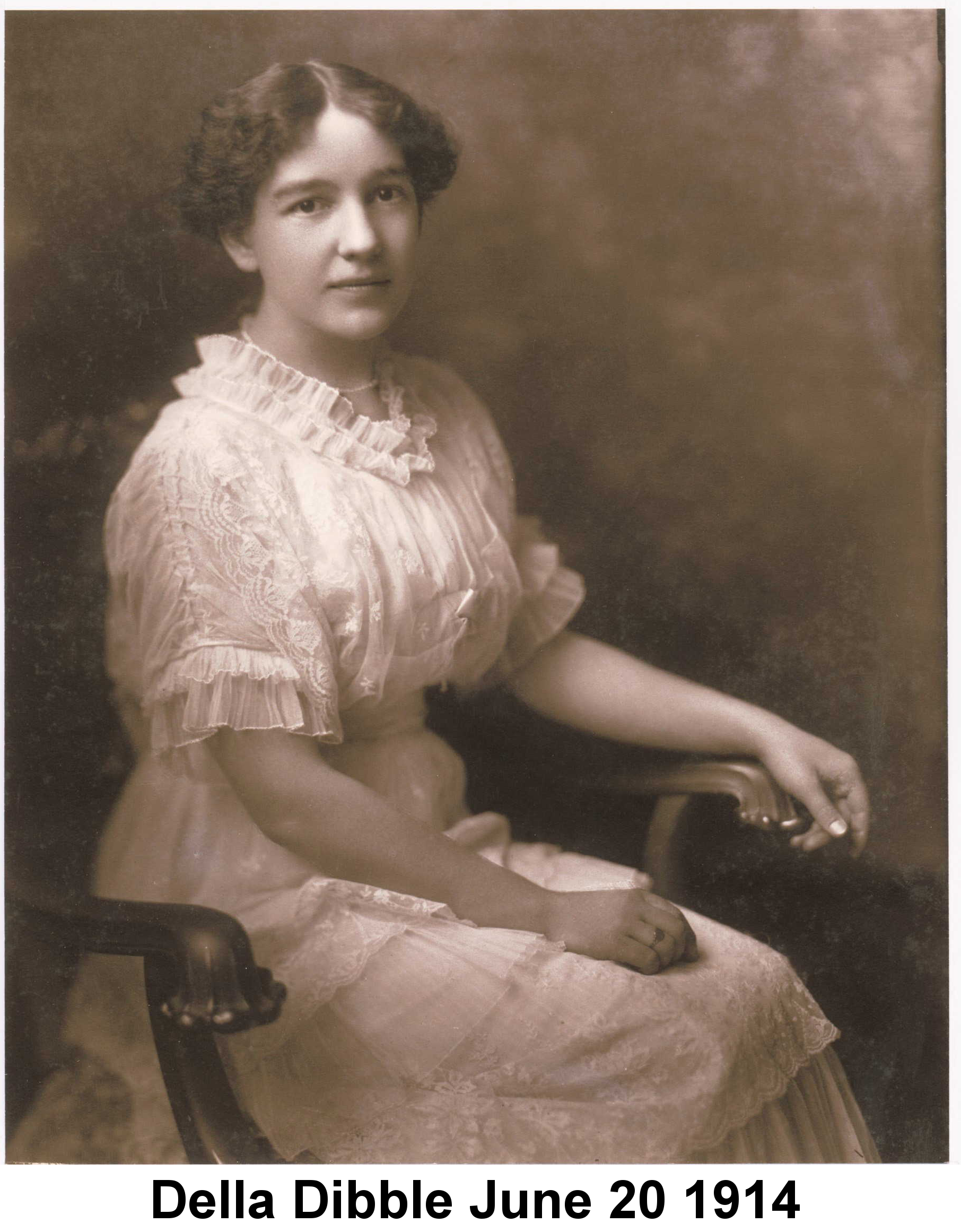 IMAGE/PHOTO: Della Dibble June 20 1914: Sepia-tone photograph of Della Dibble wearing a frilly white dress and seated in n ornate carved wooden armchair, taken June 20, 1914